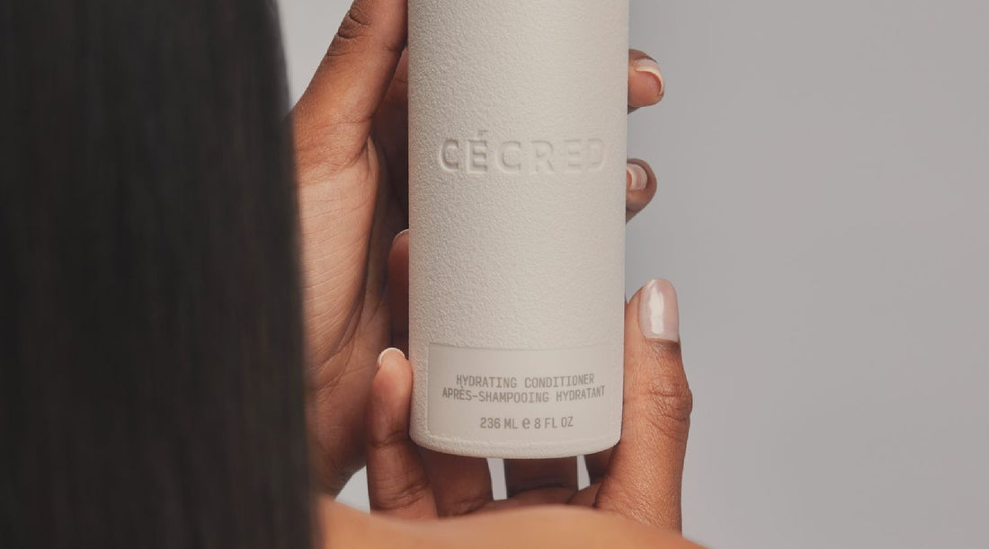 Woman holding Cécred hair care product