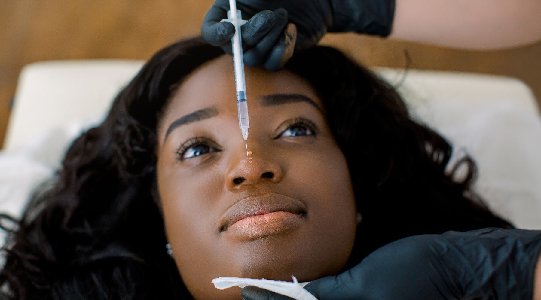 A Black woman getting botox. The Benefits of I-Tip Hair Extensions: A Medical Professional's Guide