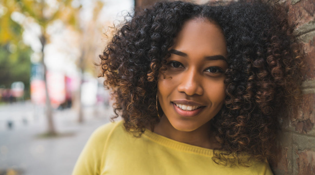 Woman showing off her curly hair with ombre tips