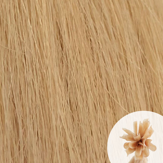 Close-up of soft ash blonde straight hair extensions with a small circular inset showing the K-Tip bundle attachment tip.