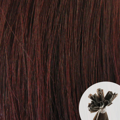 Close-up of wine dark reddish straight hair extensions with a small circular inset showing the K-Tip bundle attachment tip.