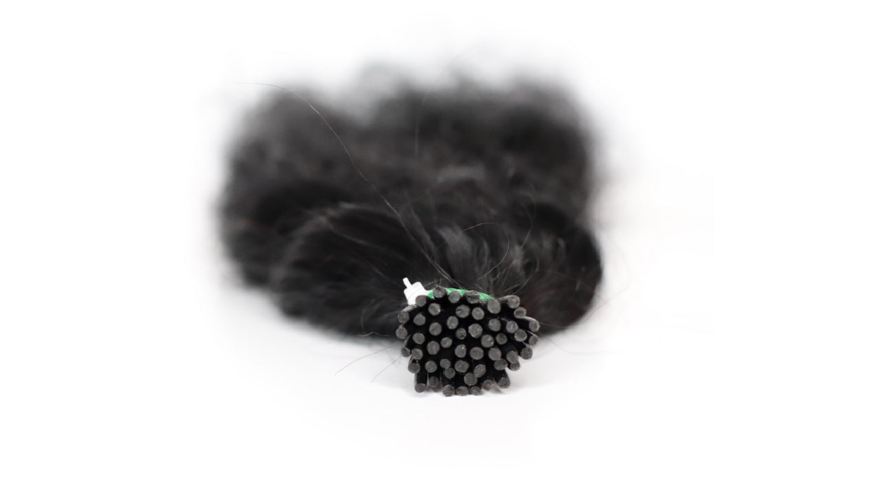 Close-up of premium I-tip hair extensions featuring durable keratin tips, designed for professional salon installations.