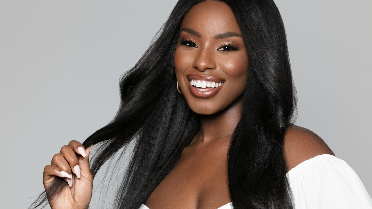 Woman with long, textured straight black hair, Fit 'n' Go wig, smiling.
