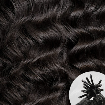 Close-up of dark brown to near-black Lao Curly 3A hair texture, with a small circular inset in the lower right showing a traditional I-tip hair extension.