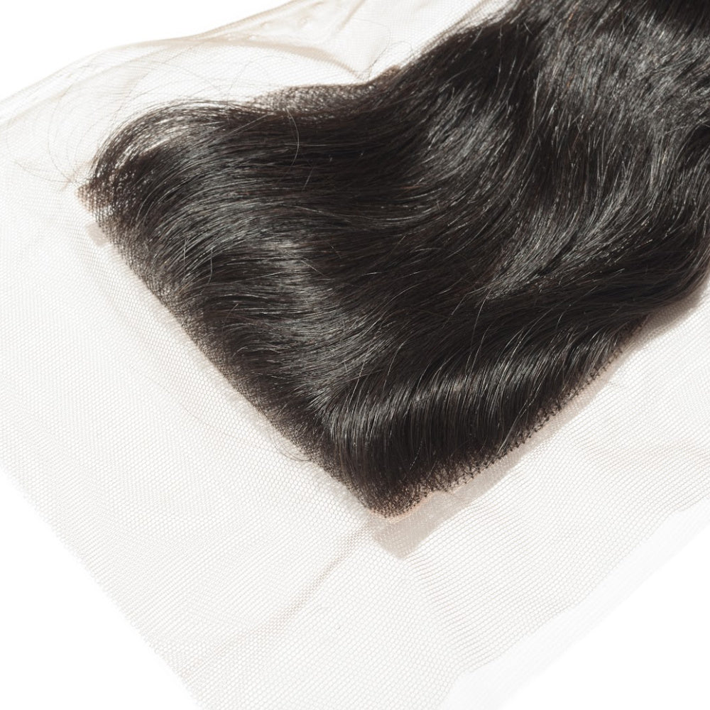 Raw Indian hair closure. Close-up of natural black hair extensions on a white background