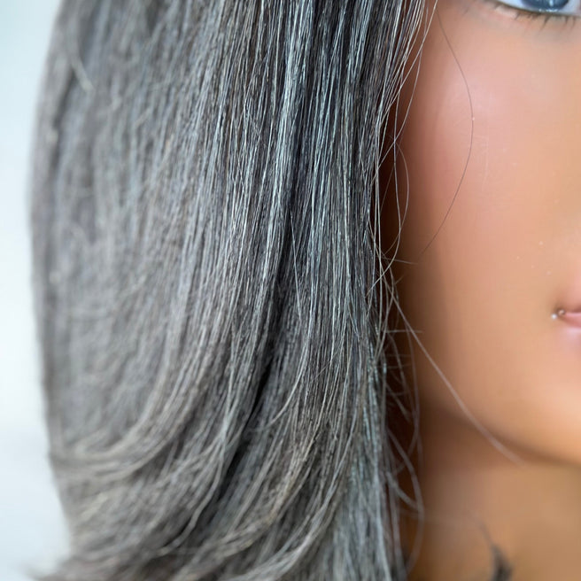 Up close color shot. Beautiful Natural gray salt and pepper Fit 'N' Go Short Bob wig for mature women. Thick and fully made of Southeast asian human hair. Crafted with precision cutting layers