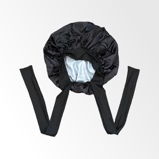 Black satin bonnet with long straps on a light gray background