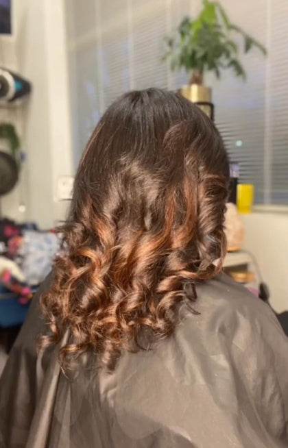 Cliente portant des extensions I-Tips Kinky Curly en cheveux vierges naturels SL avec mèches marron