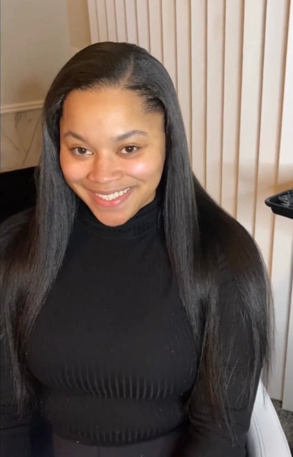 Cliente portant des extensions I-tips Kinky Curly de SL Raw Virgin Hair pour leur polyvalence en lissage