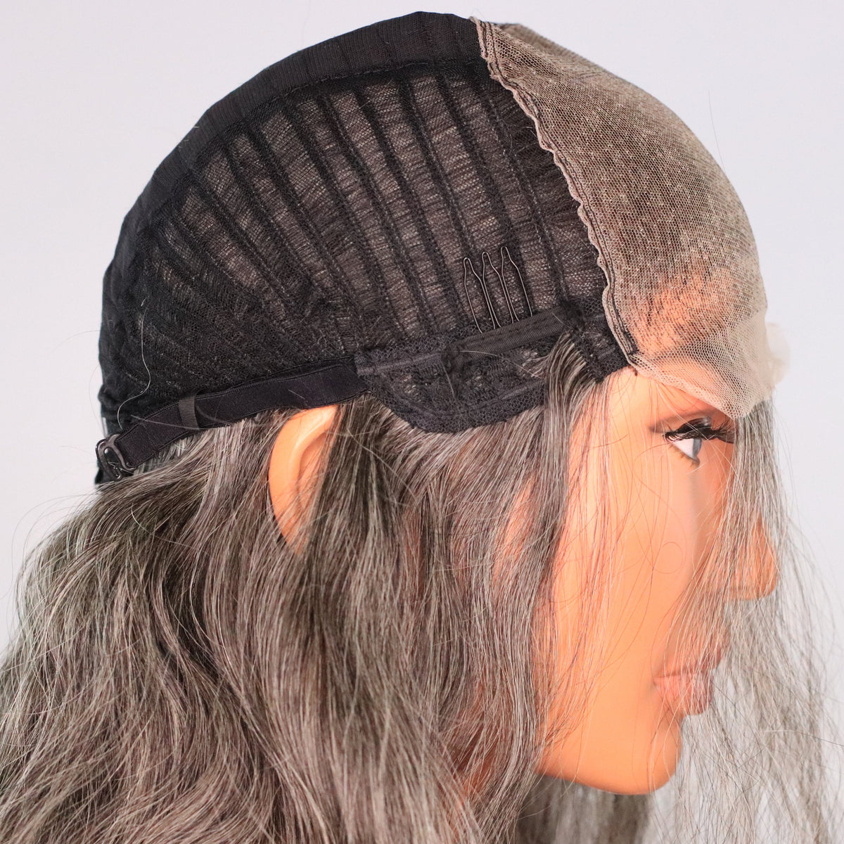 Interior side view of natural gray wig showing 5x5 HD lace, ventilated cap, comb and adjustable strap