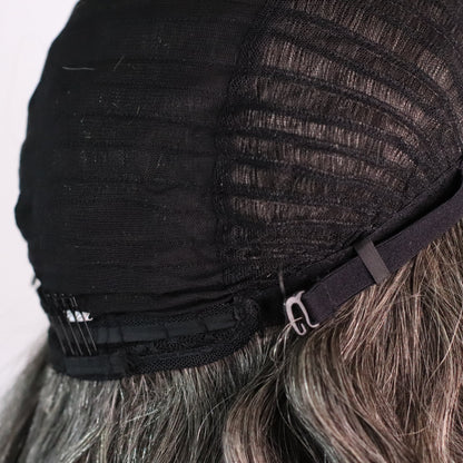 Close-up of natural gray wig cap showing adjustable strap, rear comb and ventilated construction