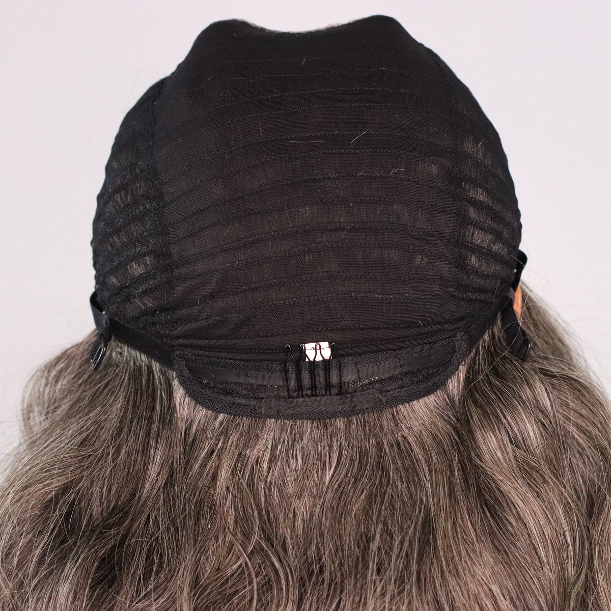 Back interior of natural gray human hair wig showing ventilated cap, rear comb and adjustable construction