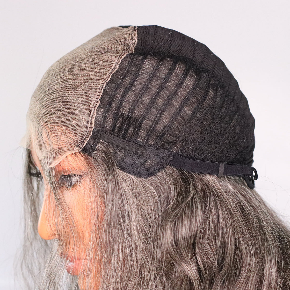 Side interior view of salt-and-pepper human hair wig showing HD lace top, cap construction and adjustable strap