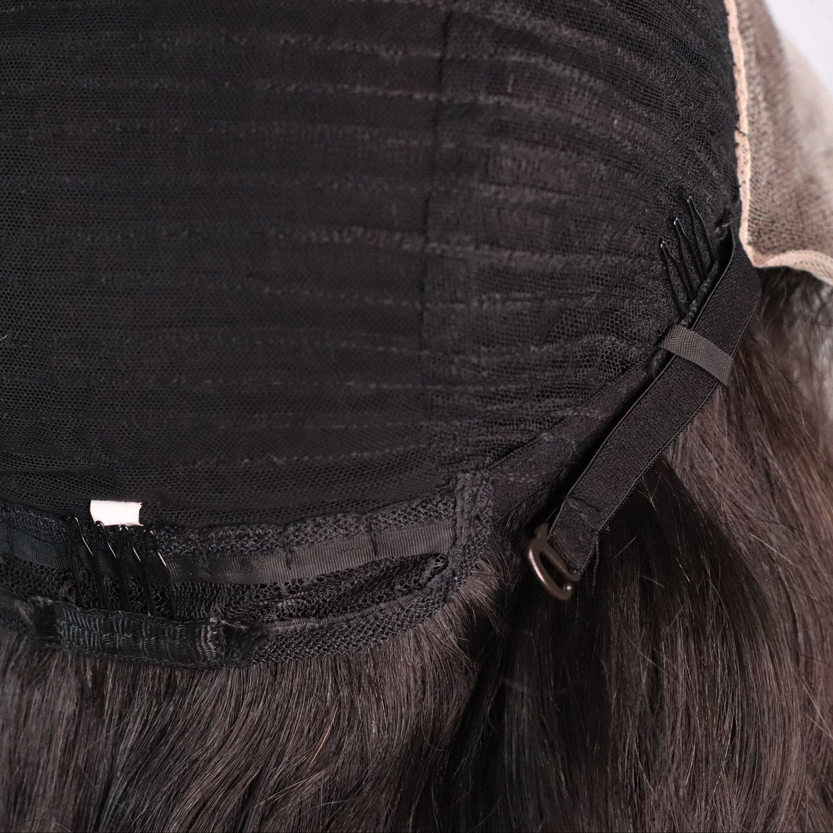 Close-up of Natural Wavy wig cap showing rear comb, adjustable strap and ventilated construction
