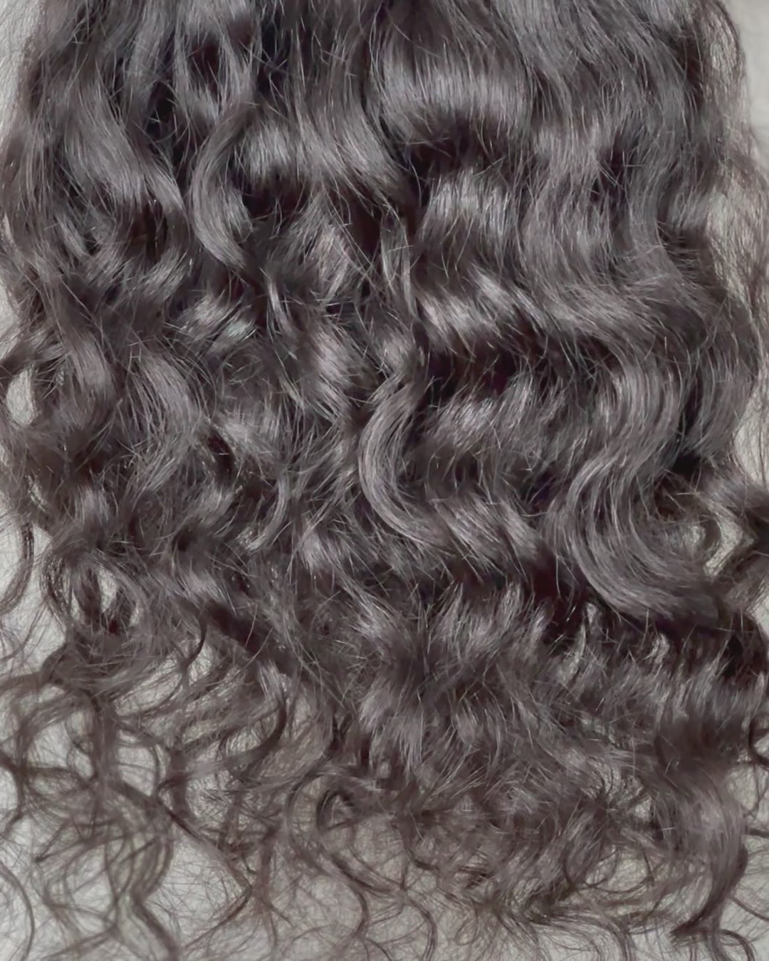Raw Indian curly hair clip-in hair extensions freshly washed with soft movement. Sold at SL Raw Virgin Hair