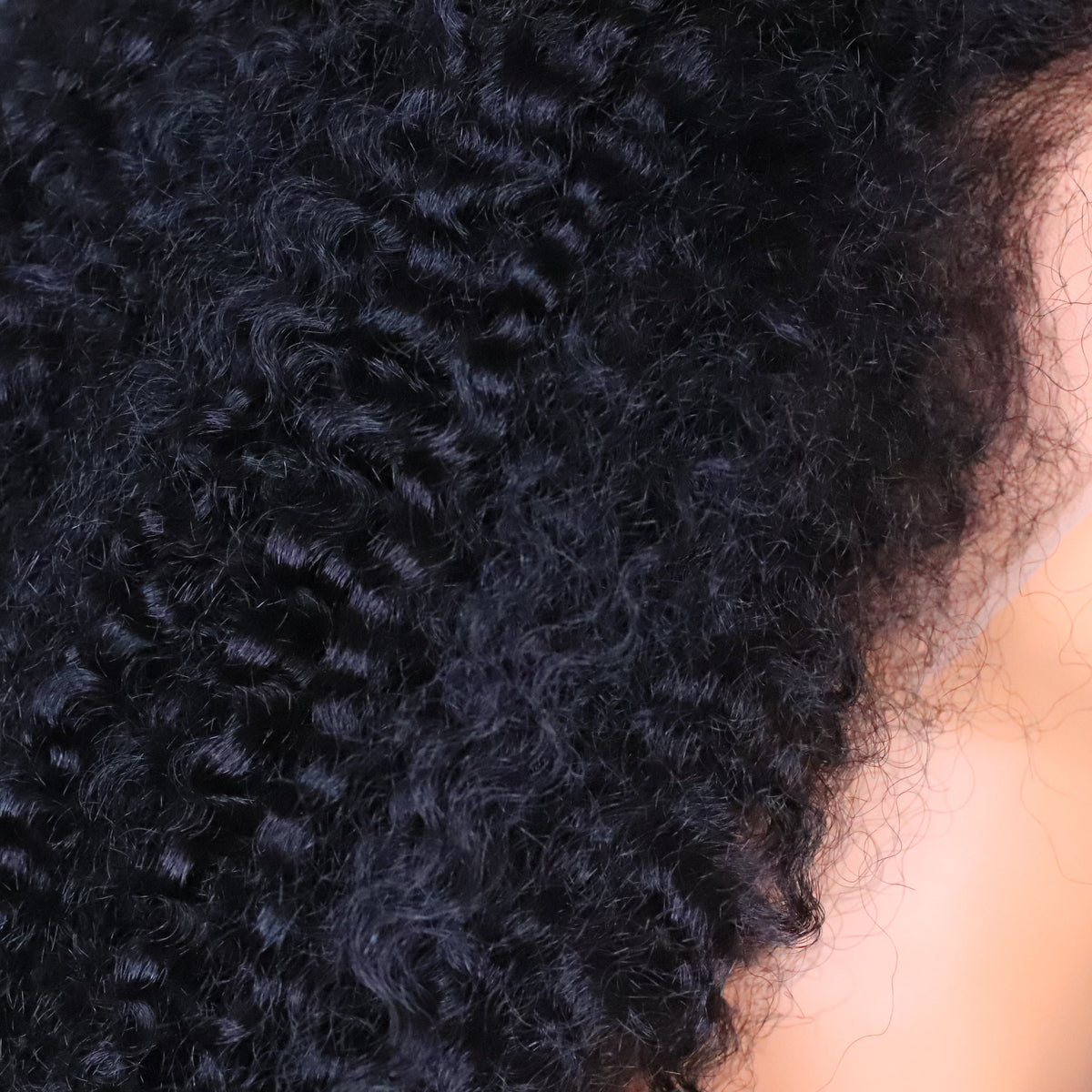 Close-up of raw Burmese Soft Kinky Curly human hair showing defined curls, natural texture and fullness near the hairline