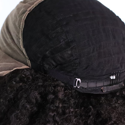 Close-up back view of a black wig with a beige lace hairline and a black elastic band with metal clips, shown on a white background.
