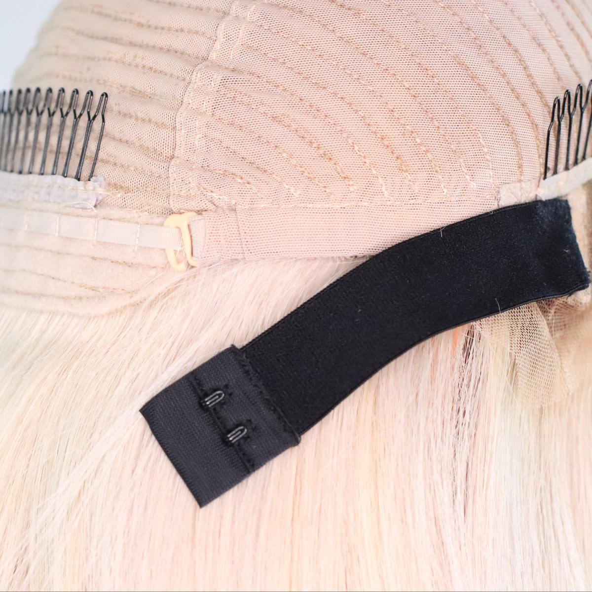 Close-up of Vixen Frost wig interior showing adjustable elastic band, hooks, straps and combs