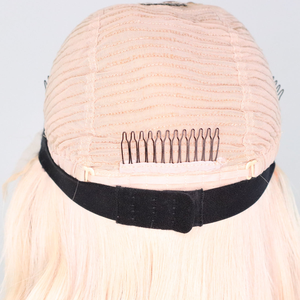 Back interior of Vixen Frost human hair wig showing security comb, adjustable straps and elastic band